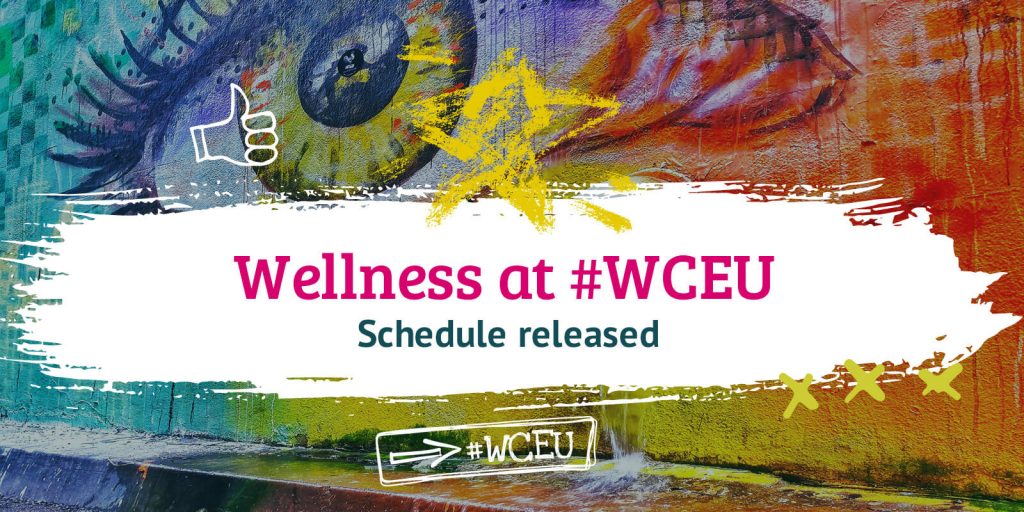 Colourful street art background with words on a white rectangle in front, saying Wellness at #WCEU and highlighting that the schedule for wellness sessions has been released